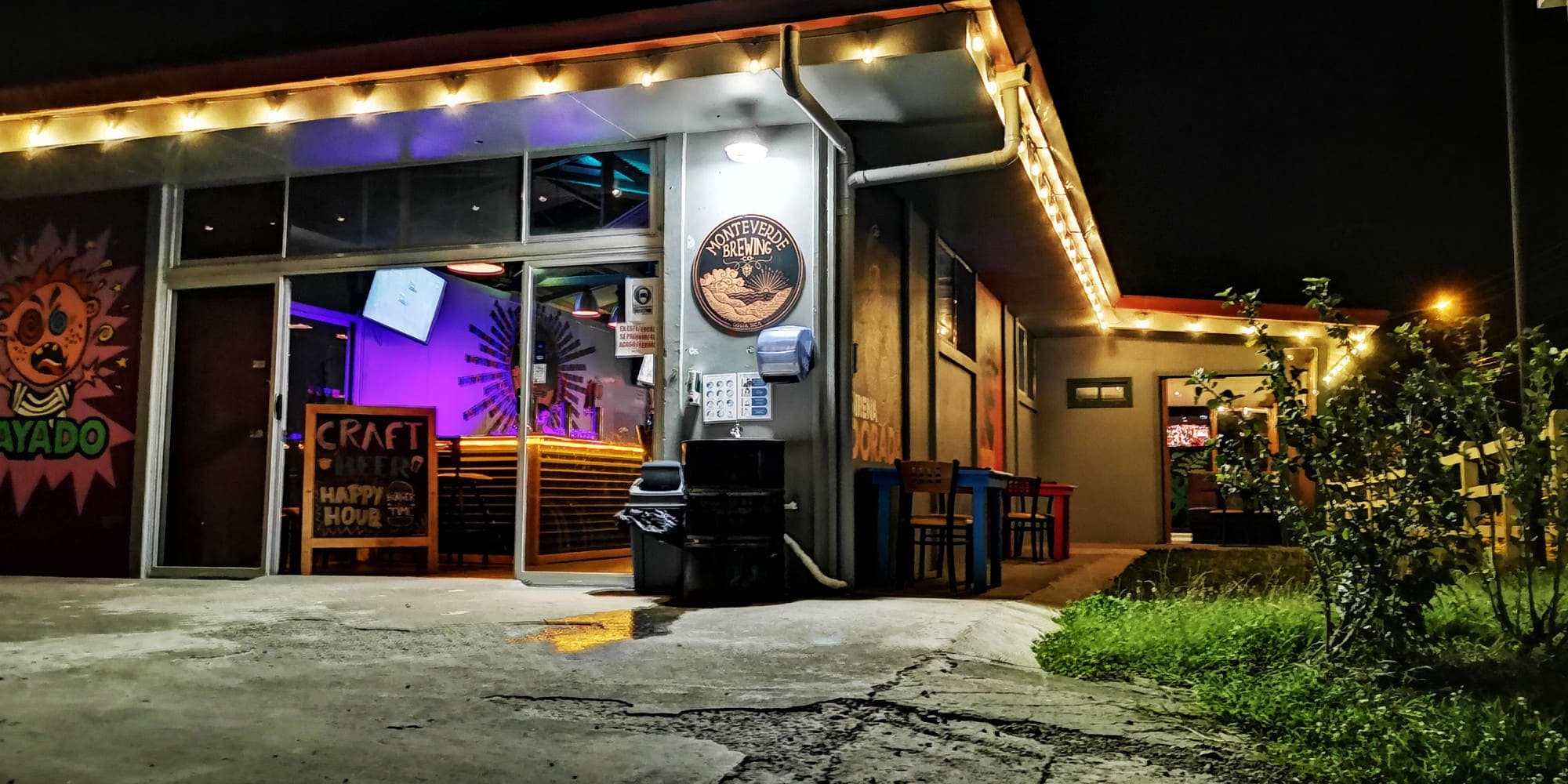 El brewpub de Monteverde Brewing Company de noche, con luces colgantes sobre la entrada