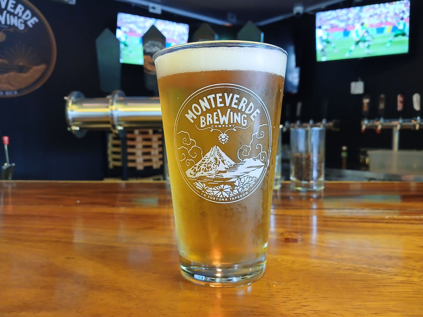 Una pinta de cerveza dorada en la barra del taproom de La Fortuna